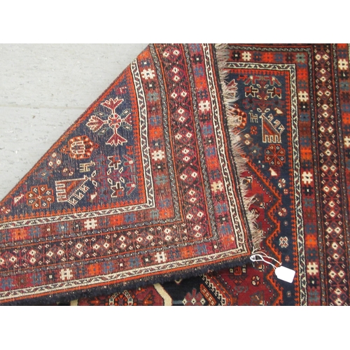 125 - A Shiraz rug, decorated with symmetrical stylised designs, on a multi-coloured ground  47