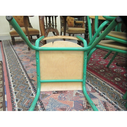 127 - A set of four mid 20thC stacking schoolroom chairs with riveted plywood backs and seats, raised on g... 