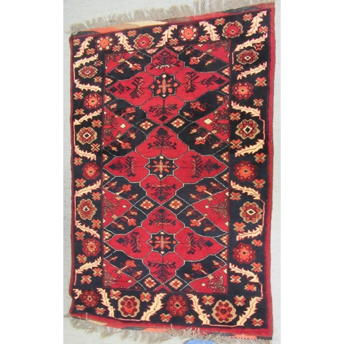 129 - A Kazak rug, decorated with stylised foliate designs, on a red and black ground  36