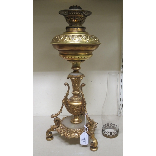 187 - A late Victorian gilt metal oil lamp of urn design, raised on scrolled legs  19