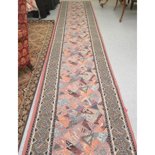 189 - An (off-cut) machine made runner, decorated in 1970s taste on a multi-coloured ground  32