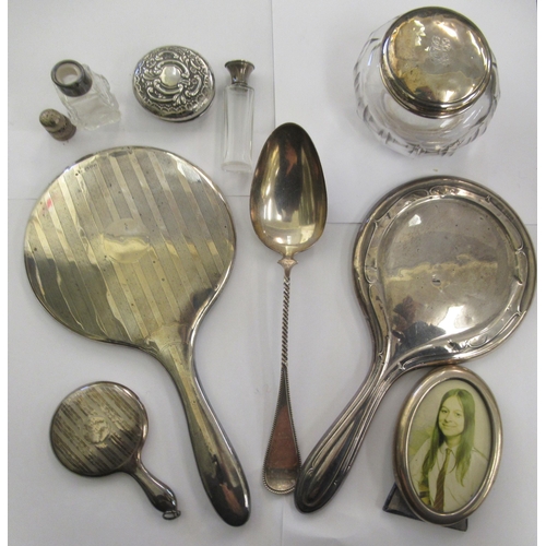 198 - Silver and silver coloured metal items: to include two hand mirrors; a powder jar; and serving spoon... 