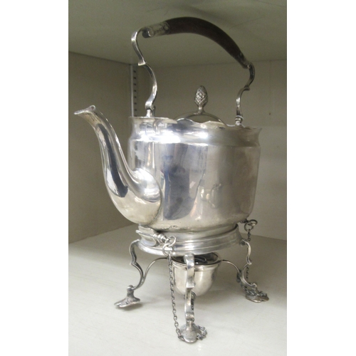 214 - An Edwardian silver kettle of oval form with a fixed, insulated top handle, hinged lid and S-shaped ... 