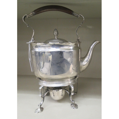 214 - An Edwardian silver kettle of oval form with a fixed, insulated top handle, hinged lid and S-shaped ... 