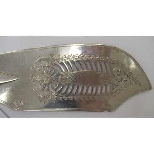 217 - A William IV silver fiddle pattern fish slice, the blade pierced, engraved and chased with a fish am... 