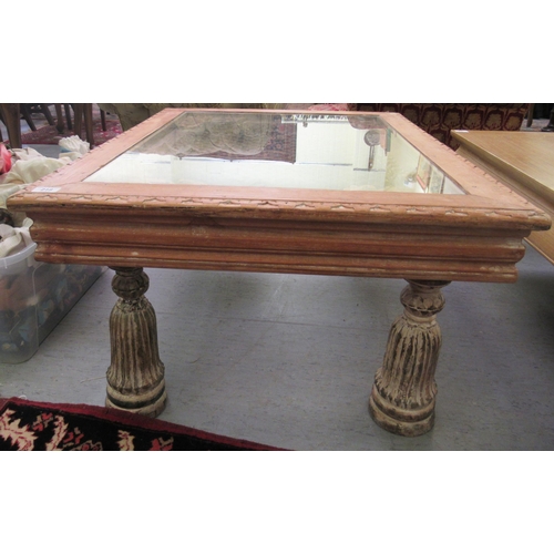 218 - A modern Indian hardwood coffee table with an inset cast iron lattice worked top, raised on urn desi... 