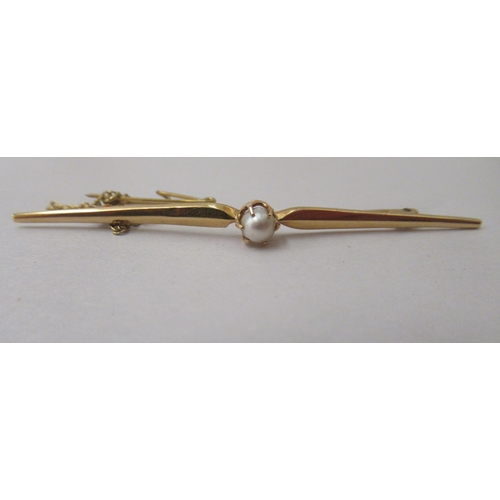 229 - An 18ct gold bar brooch, claw set with a seed pearl, on a safety chain 