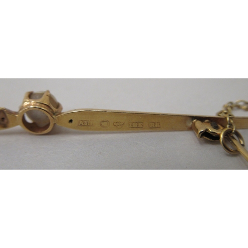 229 - An 18ct gold bar brooch, claw set with a seed pearl, on a safety chain 