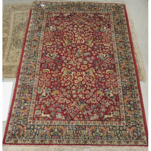 232 - A Kashan rug, with floral motifs and figures on horse back, on a red and blue ground  50