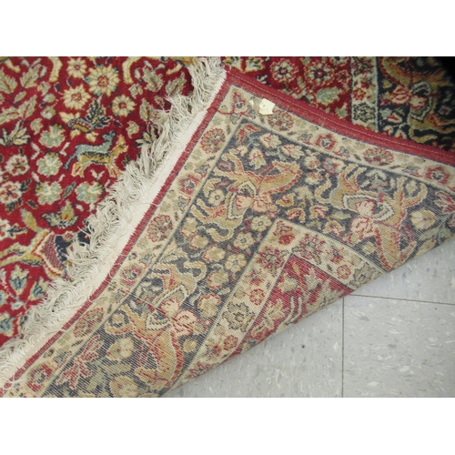 232 - A Kashan rug, with floral motifs and figures on horse back, on a red and blue ground  50