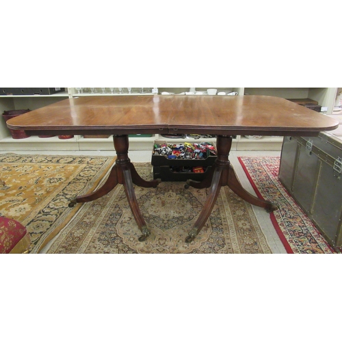 238 - An early 20thC Regency style mahogany dining table, raised on twin pedestals with splayed sabre legs... 