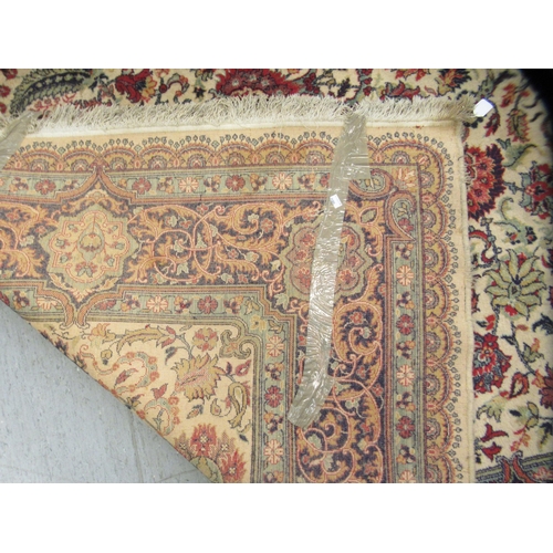 248 - A Persian design rug, decorated with repeating floral motifs, on a beige ground  100