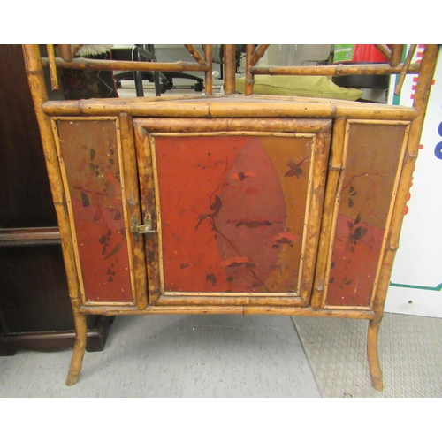 268 - An early/mid 20thC bamboo framed corner unit, having a mirrored upstand, over an open shelf and anot... 