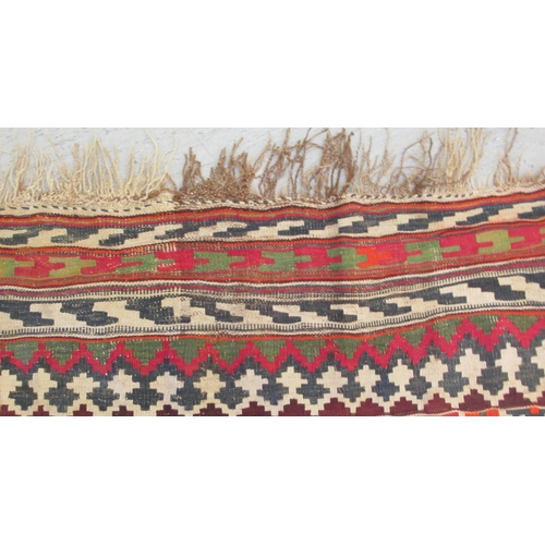 76 - A Kelim flat woven rug, decorated with repeating diamond patterns, bordered by stylised designs, on ... 