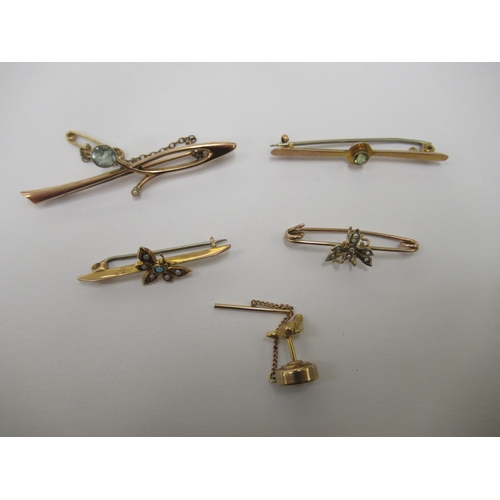 91 - Four dissimilar yellow/gold coloured metal variously set bar brooches; and a tie pin, on a safety ch... 