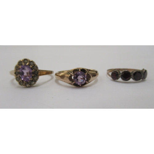 97 - Three yellow metal rings, variously set with purple stones 