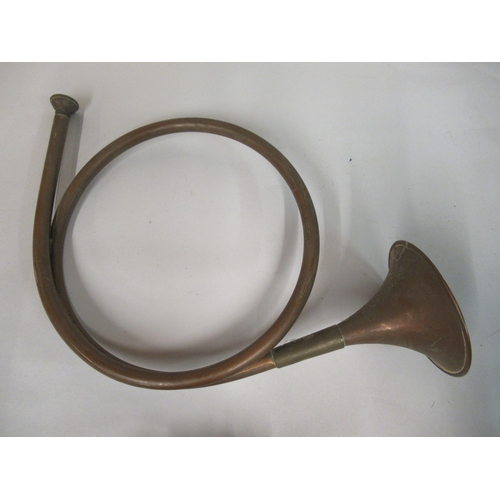140 - A military style brass bugle with a tasselled cord; a huntsman's coiled copper and brass horn; and a... 