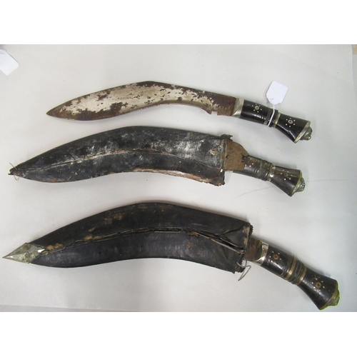 142 - Three similar Indian kukris with inlaid handles, the blades approx 12