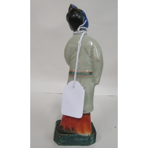 149 - A mid 18th Chinese famille rose porcelain standing figure, a market trader holding a money belt&nbsp... 