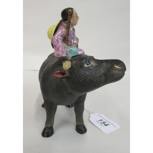 154 - An early to mid 20thC Chinese famille rose porcelain figure, a traditionally attired, smiling boy, a... 