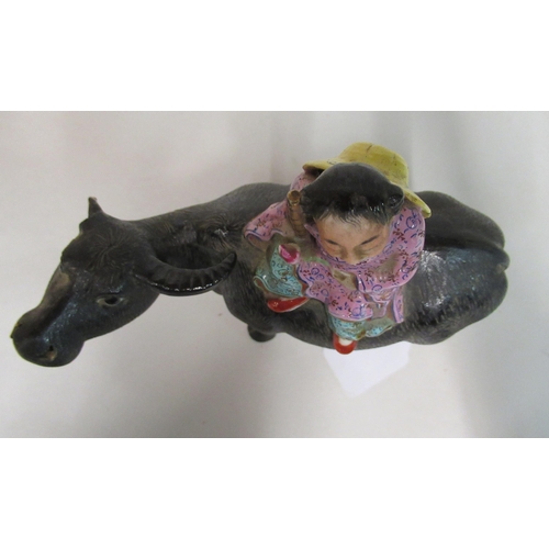 154 - An early to mid 20thC Chinese famille rose porcelain figure, a traditionally attired, smiling boy, a... 