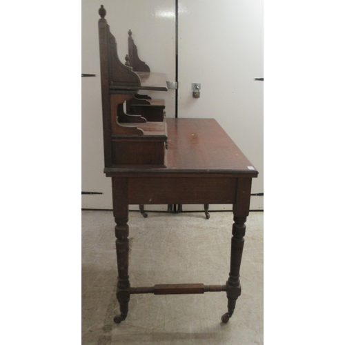 173 - An Edwardian mahogany dresser with an arrangement of open shelves and drawers, over two frieze drawe... 