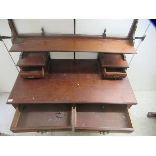 173 - An Edwardian mahogany dresser with an arrangement of open shelves and drawers, over two frieze drawe... 