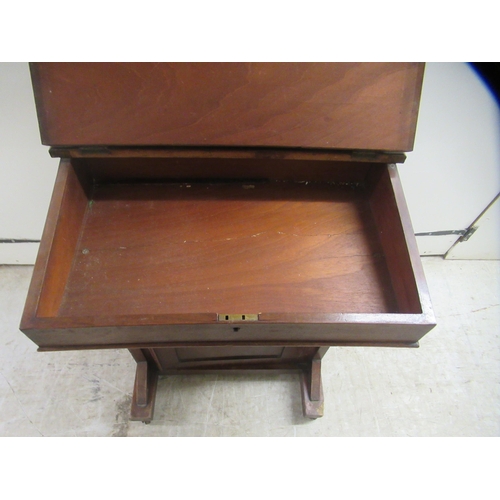 174 - A late Victorian mahogany Davenport with a hinged red hide scriber, over a panelled door, on a plint... 