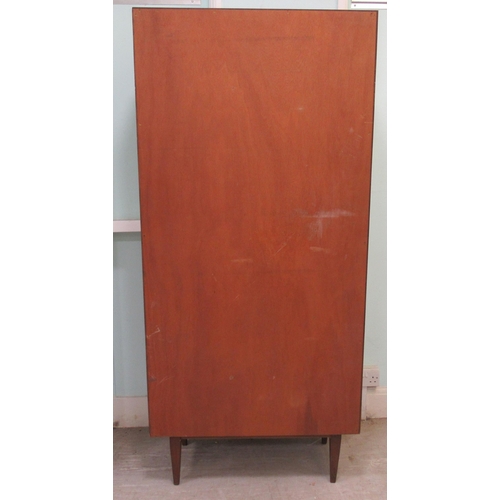 259 - A 1960s/70s teak living room unit with an arrangement of open shelves, doors and a fall flap, raised... 