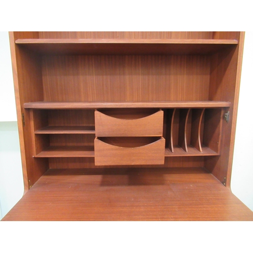 259 - A 1960s/70s teak living room unit with an arrangement of open shelves, doors and a fall flap, raised... 