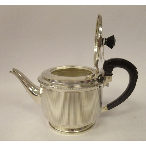 130 - A three piece silver tea set of cylindrical form with vertically line engraved ornament&nbsp; compri... 