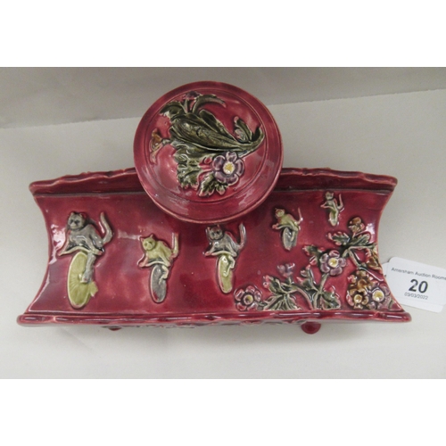 20 - A late 19thC majolica floral decorated and damsen glazed earthenware inkstand, ornamented with a ser... 