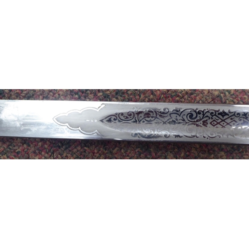 5 - A George VI military dress sword with a wire bound, shagreen handgrip, basket hilt and engraved blad... 