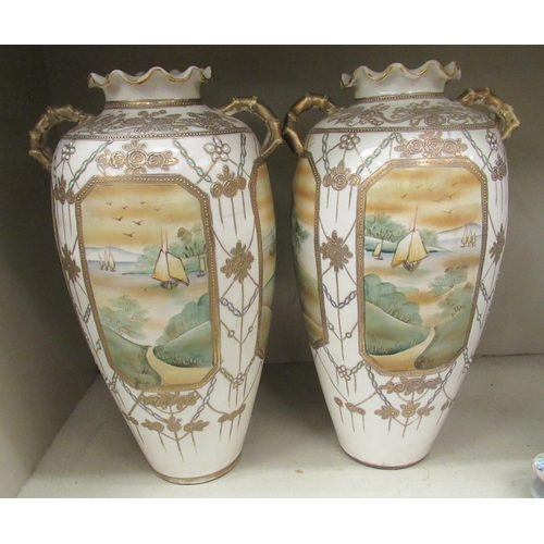 103 - A pair of 20thC Japanese twin handed porcelain baluster shaped vases, decorated with pictorial vigne... 