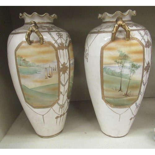 103 - A pair of 20thC Japanese twin handed porcelain baluster shaped vases, decorated with pictorial vigne... 