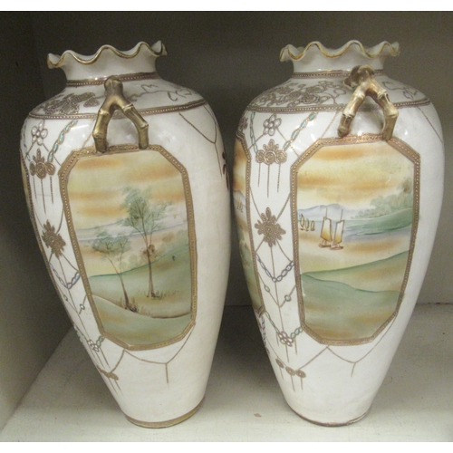 103 - A pair of 20thC Japanese twin handed porcelain baluster shaped vases, decorated with pictorial vigne... 