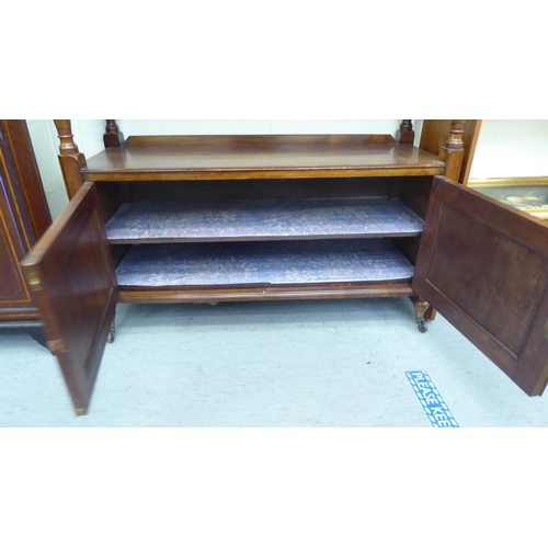 104 - A late Victorian mahogany carved buffet with two inline drawers, over an open shelf and two door cup... 