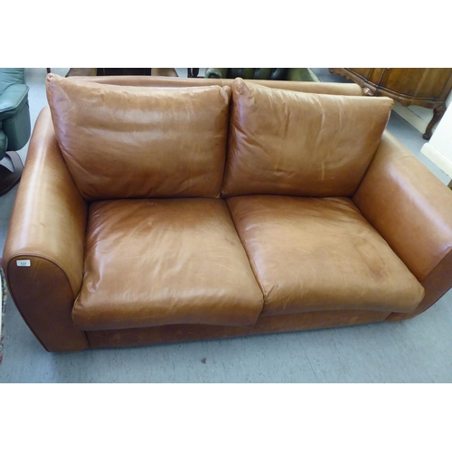 137 - A modern two person settee upholstered in stitched brown hide with a straight back and level arms&nb... 