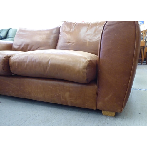 137 - A modern two person settee upholstered in stitched brown hide with a straight back and level arms&nb... 