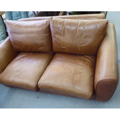 137 - A modern two person settee upholstered in stitched brown hide with a straight back and level arms&nb... 