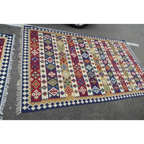 149 - Two rugs: to include an Aztec design example with geometric motifs, on a multi-coloured ground  82