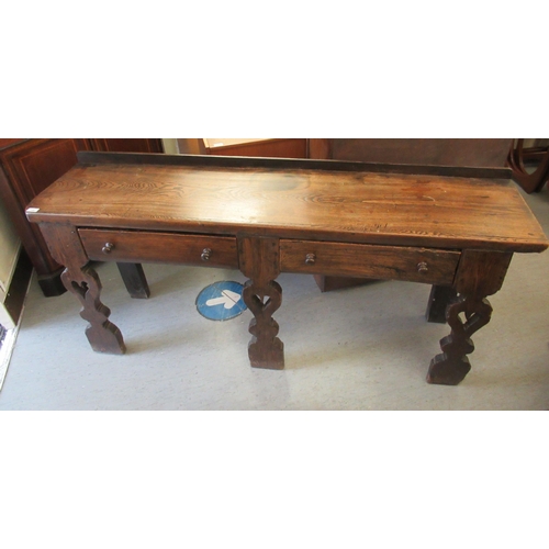 152 - An early 18thC rustically constructed elm and oak two drawer dresser, raised on carved and pierced p... 