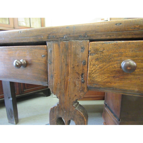 152 - An early 18thC rustically constructed elm and oak two drawer dresser, raised on carved and pierced p... 