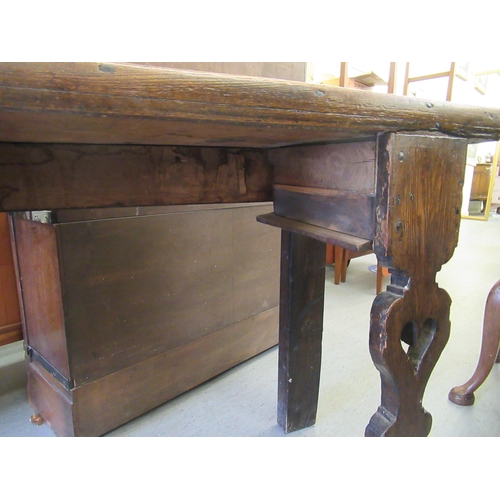 152 - An early 18thC rustically constructed elm and oak two drawer dresser, raised on carved and pierced p... 