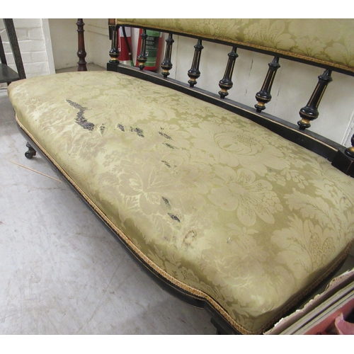 185 - A late Victorian ebonised and gilded showwood framed salon settee with a level, scrolled back on tur... 