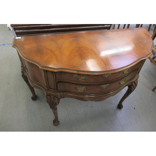 191 - A modern crossbanded walnut and mahogany serpentine front canteen sideboard with a hinged lid, enclo... 