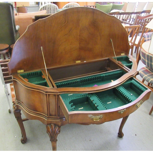 191 - A modern crossbanded walnut and mahogany serpentine front canteen sideboard with a hinged lid, enclo... 