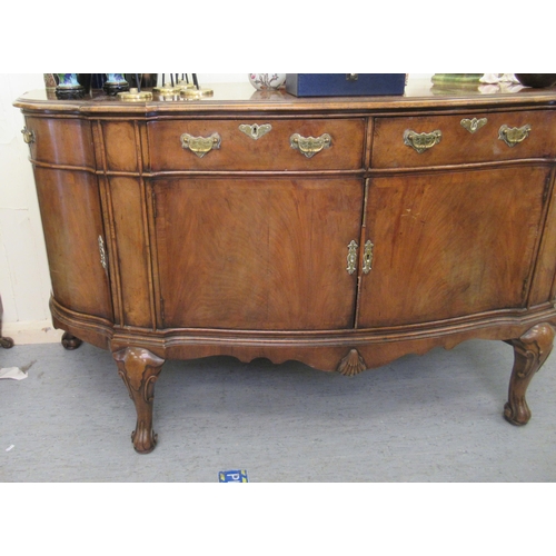 192 - A modern crossbanded walnut and mahogany serpentine front sideboard with two frieze drawers, over a ... 