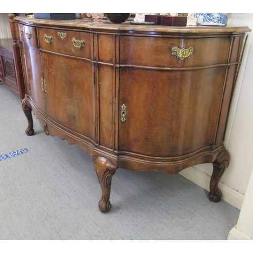 192 - A modern crossbanded walnut and mahogany serpentine front sideboard with two frieze drawers, over a ... 