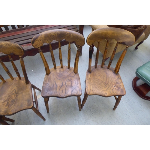 198 - A set of four early 20thC beech and elm framed Windsor kitchen chairs, the solid seats raised on tur... 